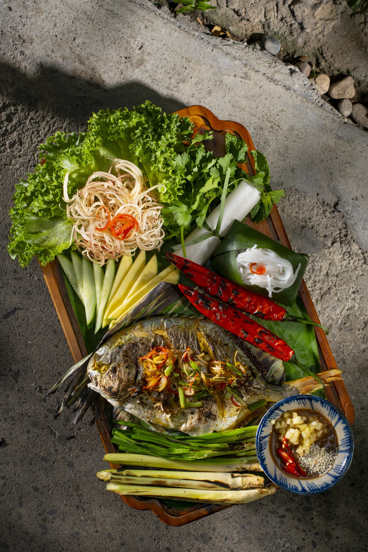 Banana leaf-grilled sea fish with garden herbs, rice paper and pineapple anchovy sauce