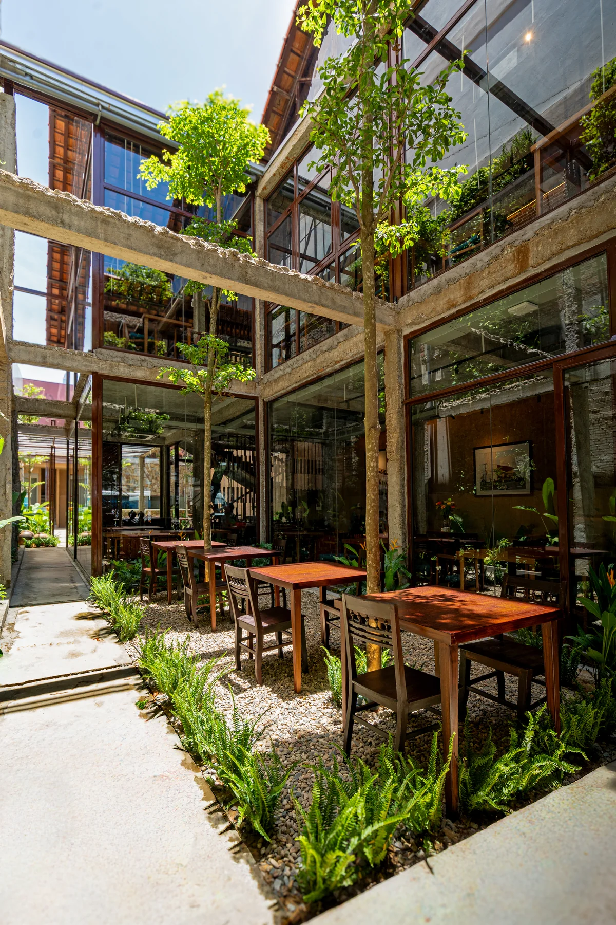 Sunlight, planted edges and open roof structures around MiRi Hôm’s courtyard