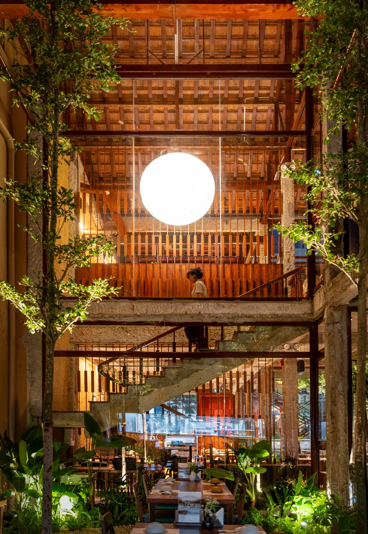 Tiled roofs, planted edges and a stairway above the MiRi Hôm dining room