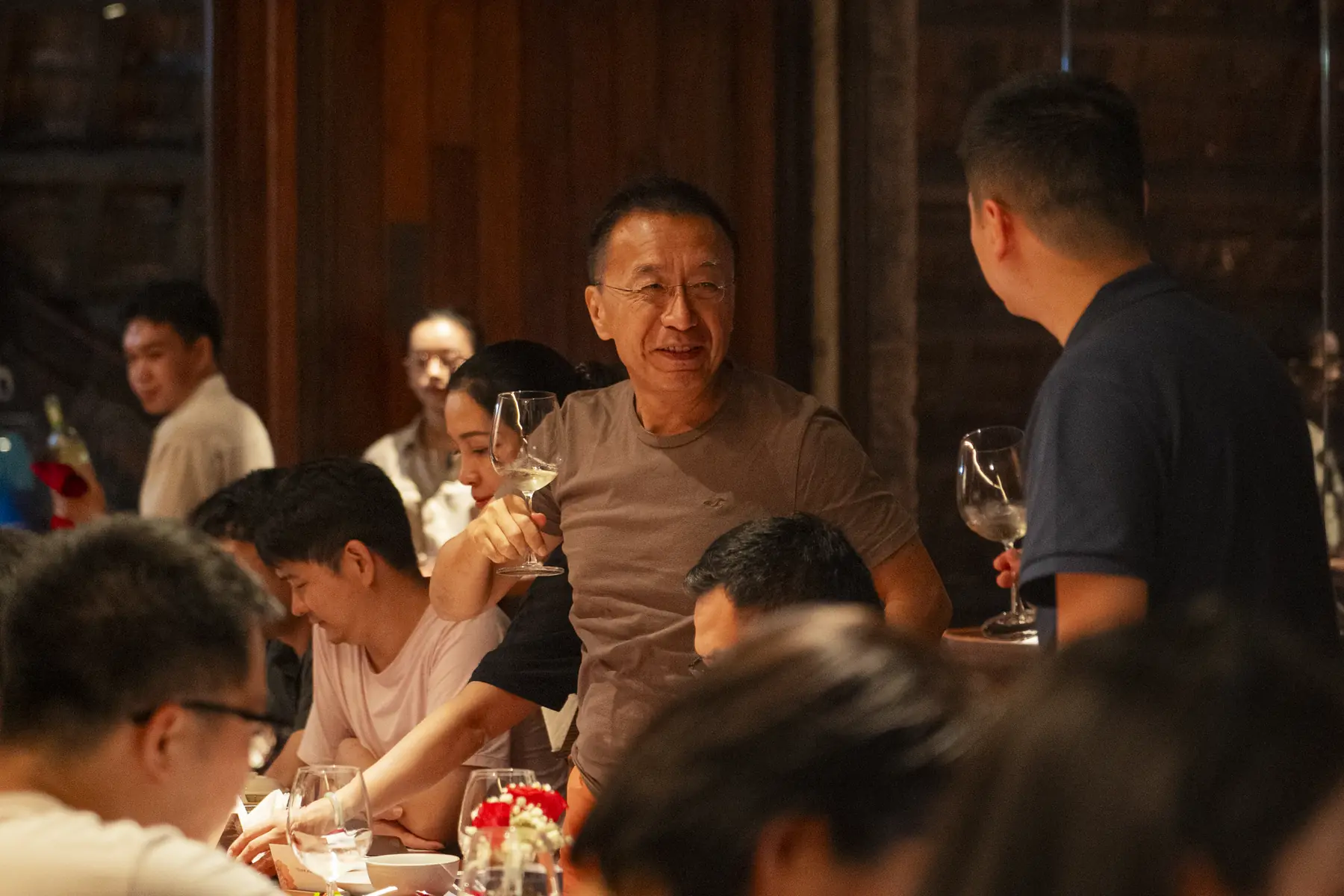 Guests sharing wine during an evening meal at MiRi Hôm